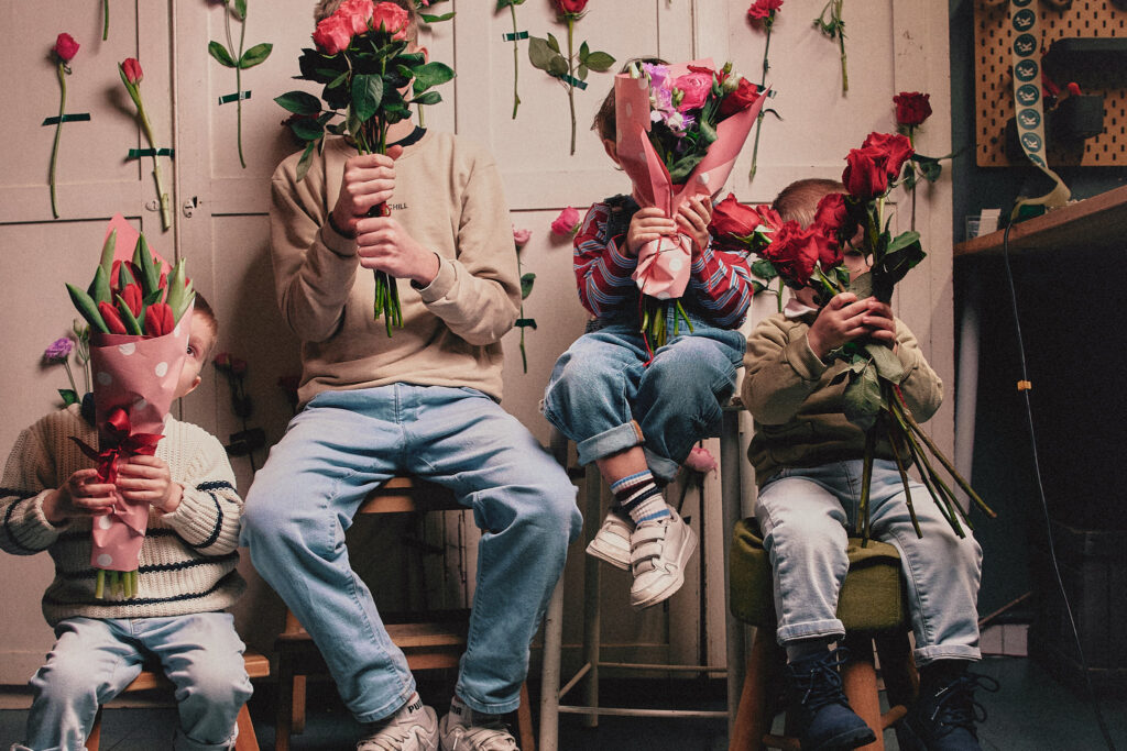 Bambini si nascondono dietro amazzi di fiori