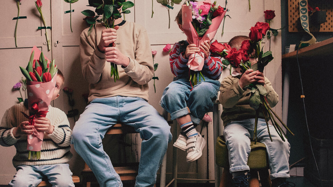 Bambini si nascondono dietro amazzi di fiori