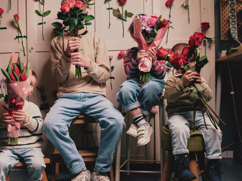 Bambini si nascondono dietro amazzi di fiori